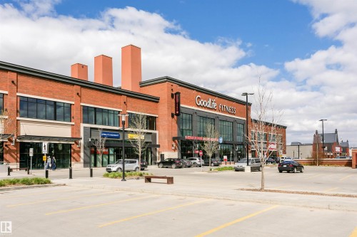 Commercial plaza featuring red brick and dark-framed storefront windows - #106 12110 106 Av Nw, Edmonton, AB - Outdoor