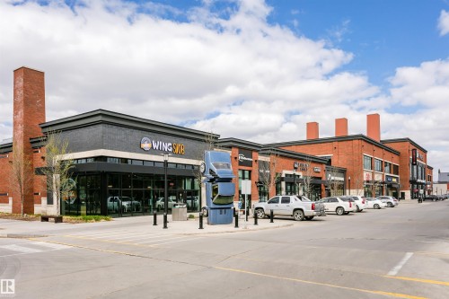 Modern brick and black facade commercial building featuring extensive storefront windows - #106 12110 106 Av Nw, Edmonton, AB - Outdoor