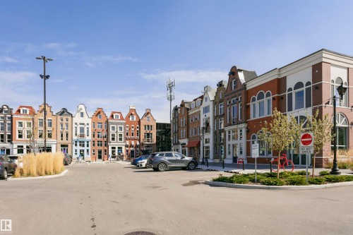 Streetscape featuring diverse architectural styles, brick and stucco facades, multiple windows, and ground-level retail spaces - #106 12110 106 Av Nw, Edmonton, AB - Outdoor With Facade