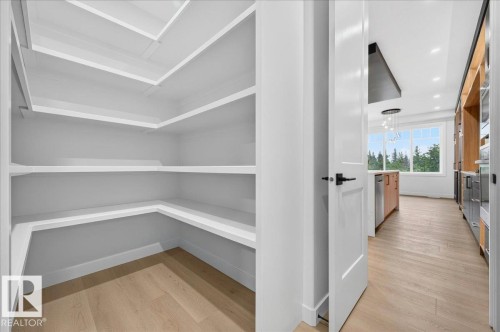 Walk-in pantry featuring extensive built-in shelving, wood-finish flooring, and white baseboards - 427 172 Avenue Nw, Edmonton, AB - Indoor Photo Showing Other Room