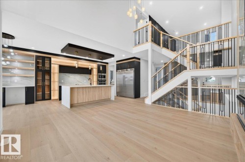 Open-concept interior featuring light wood-finish flooring throughout the main level - 427 172 Avenue Nw, Edmonton, AB - Indoor
