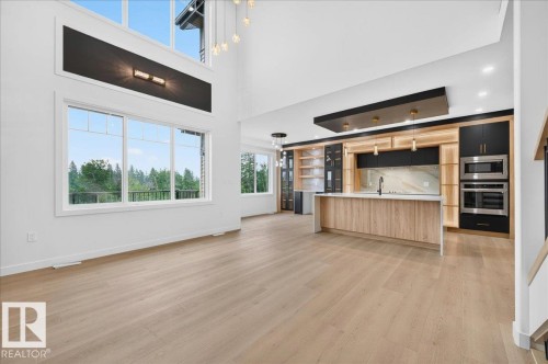 Open-concept living space with light wood-finish flooring, high ceilings, and large windows - 427 172 Avenue Nw, Edmonton, AB - Indoor Photo Showing Kitchen