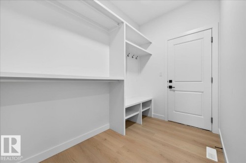 Mudroom featuring built-in white shelving, integrated coat hooks, and bench seating with cubbies - 427 172 Avenue Nw, Edmonton, AB - Indoor