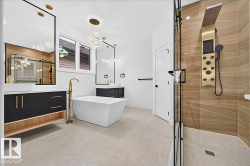 Contemporary bathroom featuring a freestanding soaking tub with a floor-mounted gold-tone faucet, dual floating vanities with vessel sinks, and a glass-enclosed shower with a multi-function shower panel - 427 172 Avenue Nw, Edmonton, AB - Indoor Photo Showing Bathroom