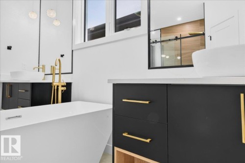 Freestanding soaking tub with a floor-mounted brass fixture - 427 172 Avenue Nw, Edmonton, AB - Indoor