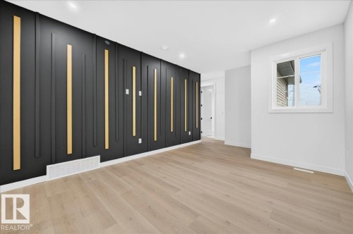 Accent wall featuring dark paneling with vertical gold-toned inserts - 427 172 Avenue Nw, Edmonton, AB - Indoor Photo Showing Other Room
