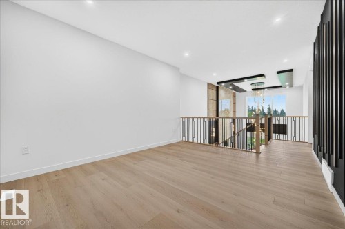 Open concept upper-level space featuring light wood-finish flooring and a contemporary railing design - 427 172 Avenue Nw, Edmonton, AB - Indoor Photo Showing Other Room
