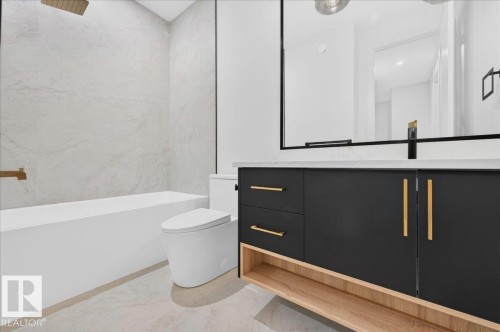 Contemporary bathroom featuring a black vanity with gold hardware, a white countertop, and a large black-framed mirror - 427 172 Avenue Nw, Edmonton, AB - Indoor Photo Showing Bathroom
