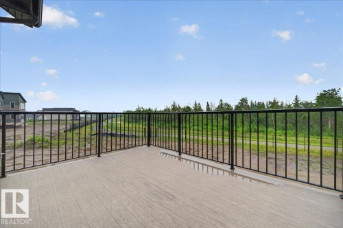 Outdoor deck featuring composite wood-finish flooring and black metal railings - 427 172 Avenue Nw, Edmonton, AB - Outdoor