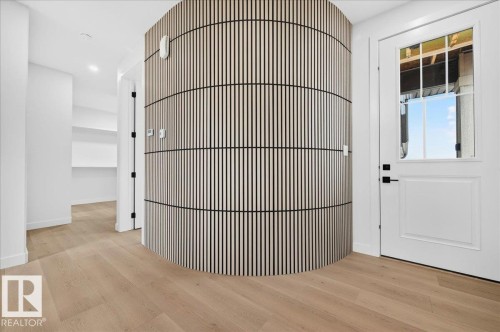 Curved accent wall with vertical wood slat detailing - 427 172 Avenue Nw, Edmonton, AB - Indoor Photo Showing Other Room