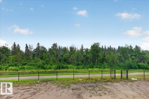 Expansive natural landscape bordering the property, featuring a paved path and a black chain-link fence - 427 172 Avenue Nw, Edmonton, AB - Outdoor With View