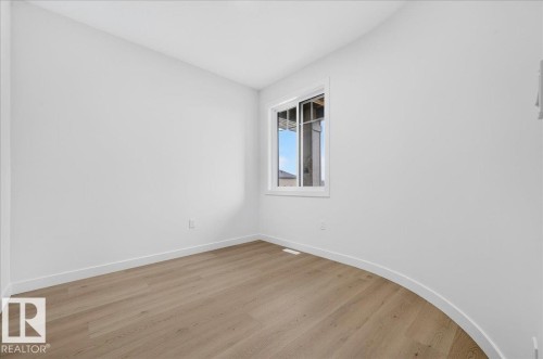 Room featuring light wood-finish flooring, white painted walls, white trim, and a white-framed window - 427 172 Avenue Nw, Edmonton, AB - Indoor Photo Showing Other Room