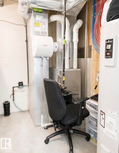 Utility space featuring a water heater, furnace, and exposed ductwork - 5135 1A Avenue Sw, Edmonton, AB - Indoor Photo Showing Basement