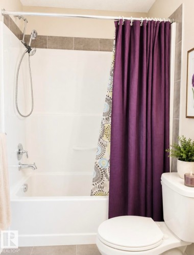 Bathtub with integrated shower, featuring a chrome showerhead and faucet - 5135 1A Avenue Sw, Edmonton, AB - Indoor Photo Showing Bathroom