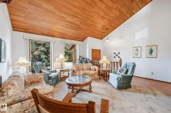 Vaulted ceiling with wood paneling, white walls, and large windows - 