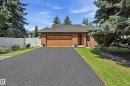 Brick exterior with an attached garage featuring a wood-panel door - 4108 Ramsay Road Nw, Edmonton, AB  - Outdoor 