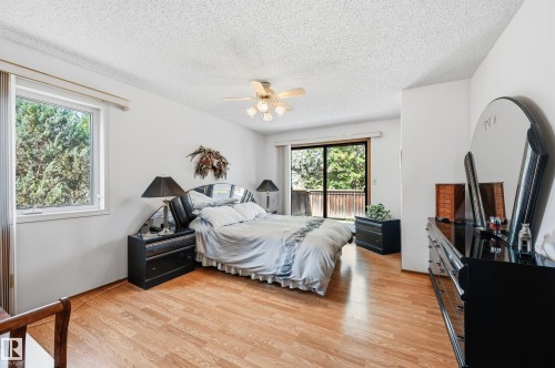Bedroom featuring wood-finish flooring, a ceiling fan with integrated lighting, and a sliding glass door leading to an outdoor space - 4108 Ramsay Road Nw, Edmonton, AB - Indoor Photo Showing Bedroom