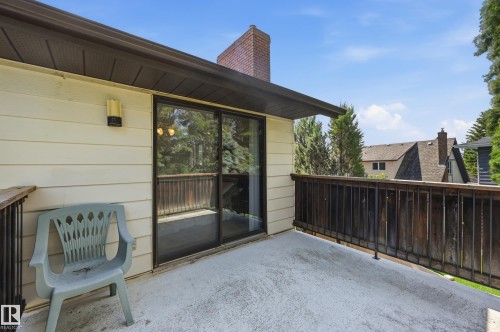 Outdoor deck featuring a concrete surface, wooden railing, and a sliding glass door entry - 4108 Ramsay Road Nw, Edmonton, AB - Outdoor With Deck Patio Veranda With Exterior