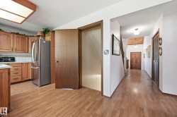 Kitchen area featuring wood-finish flooring, light wood cabinetry, and a white countertop - 