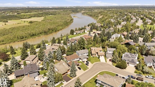 Residential neighborhood featuring a meandering river, mature tree canopy, varied architectural styles, and solar panel installations on select rooftops - 4108 Ramsay Road Nw, Edmonton, AB - Outdoor With View