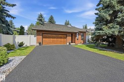 Brick exterior featuring an attached double garage with a wood-panel door - 