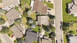 Residential properties featuring shingle roofs, private yards with mature trees, and paved driveways - 