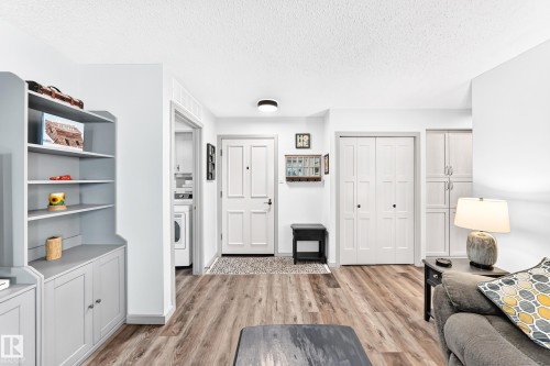 Laminate wood-finish flooring extending from the entryway - #401 14810 51 Av Nw, Edmonton, AB - Indoor