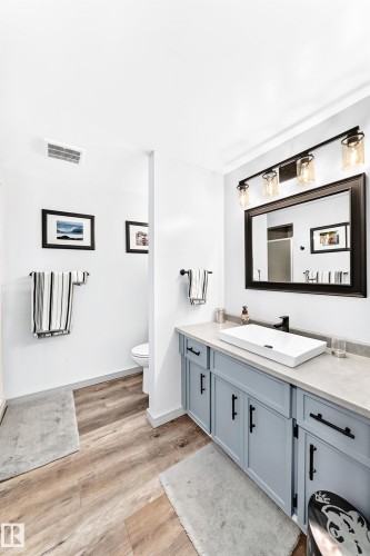 Bathroom vanity featuring a rectangular vessel sink, matte black faucet, and light blue cabinetry with dark hardware - #401 14810 51 Av Nw, Edmonton, AB - Indoor Photo Showing Bathroom