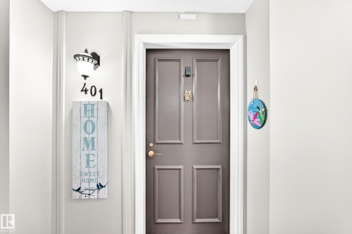 Panel-style entry door with brass hardware - #401 14810 51 Av Nw, Edmonton, AB - Indoor Photo Showing Other Room