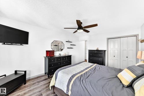 Bright interior with wood-finish flooring, a ceiling fan with integrated lighting, and a bi-fold closet - #401 14810 51 Av Nw, Edmonton, AB - Indoor Photo Showing Bedroom