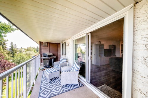 Private balcony featuring concrete flooring, white metal railing, and a sliding glass door entry - #401 14810 51 Av Nw, Edmonton, AB - Outdoor With Balcony With Exterior