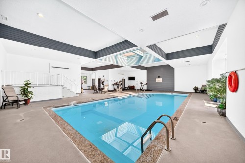 Indoor swimming pool with concrete decking and perimeter railing - #401 14810 51 Av Nw, Edmonton, AB -  With In Ground Pool With Exterior