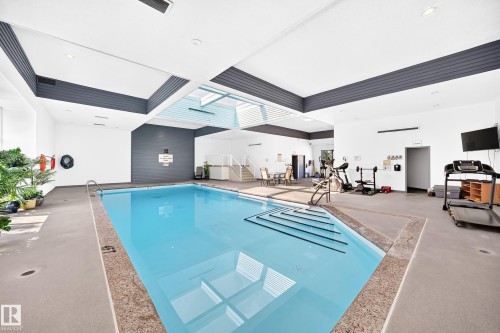 Indoor swimming pool featuring an integrated staircase, surrounding non-slip flooring, and ample natural light from ceiling windows - #401 14810 51 Av Nw, Edmonton, AB -  Photo Showing Other Room With In Ground Pool