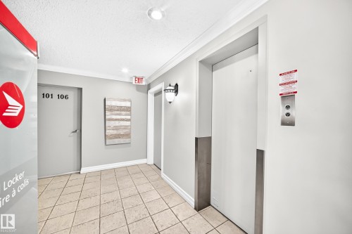 Well-lit common area featuring neutral-toned walls, crown molding, and a tiled floor - #401 14810 51 Av Nw, Edmonton, AB - Indoor Photo Showing Other Room