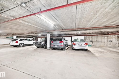 Underground parking garage featuring concrete flooring and ceiling - #401 14810 51 Av Nw, Edmonton, AB - Indoor Photo Showing Garage