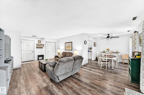 Open-concept living and dining area featuring wood-finish flooring, recessed lighting, and a ceiling fan - #401 14810 51 Av Nw, Edmonton, AB - Indoor Photo Showing Living Room