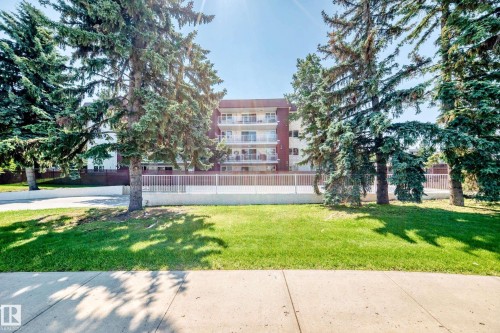 Multi-story residential building featuring a red brick exterior and white balcony railings - #401 14810 51 Av Nw, Edmonton, AB - Outdoor
