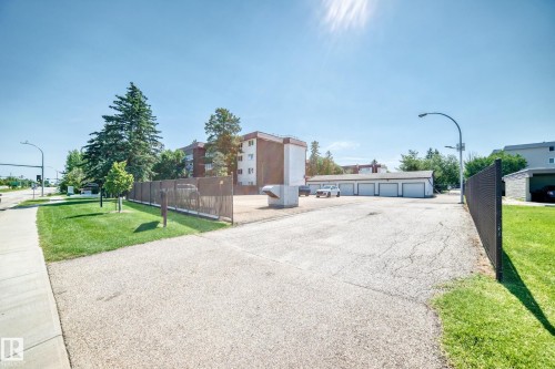 Paved lot with perimeter fencing and grass border - #401 14810 51 Av Nw, Edmonton, AB - Outdoor