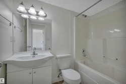 Bathroom featuring a vanity with integrated sink, chrome faucet, and mirrored cabinet - 
