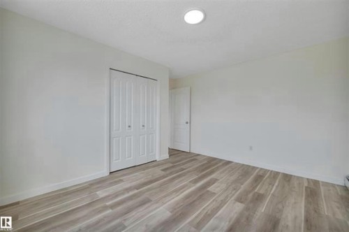Room featuring wood-finish flooring, recessed ceiling lighting, and white bi-fold closet doors - #10 4616 47 St, Leduc, AB - Indoor Photo Showing Other Room