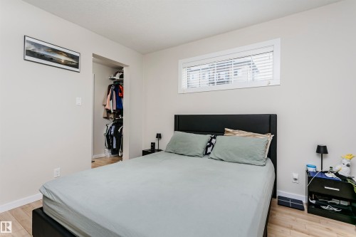Light wood-finish flooring provides a bright base for this room - #104 9519 160 Av Nw, Edmonton, AB - Indoor Photo Showing Bedroom