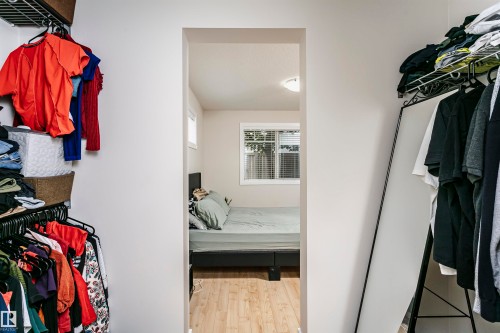 Interior room with wood-finish flooring, two windows with blinds, and recessed lighting - #104 9519 160 Av Nw, Edmonton, AB 