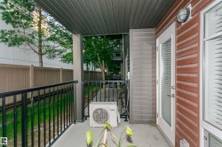 Private outdoor patio featuring a concrete surface and black metal railing - 