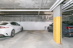 Underground parking space featuring concrete flooring and exposed ceiling utilities - 
