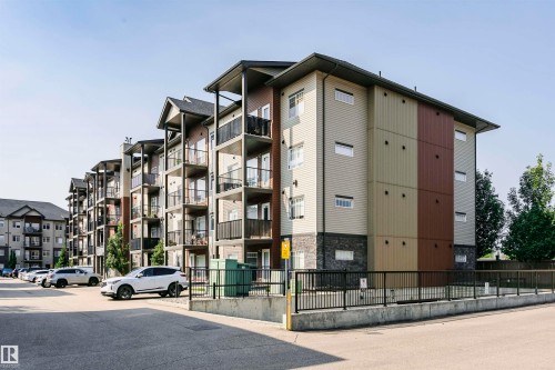 Multi-story residential building featuring a modern facade with mixed siding materials and stone accents - #104 9519 160 Av Nw, Edmonton, AB - Outdoor With Facade