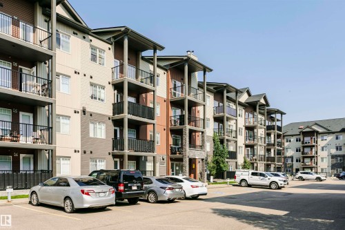 Contemporary multi-story condominium building featuring a mix of horizontal siding, stone accents, and dark trim - #104 9519 160 Av Nw, Edmonton, AB - Outdoor With Facade