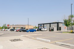 Commercial building featuring a grey facade with black trim and a prominent storefront sign - 