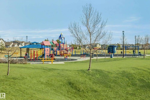 Neighborhood park featuring extensive playground equipment, multiple swing sets, covered picnic tables, and abundant open green space - #104 9519 160 Av Nw, Edmonton, AB - Outdoor With View