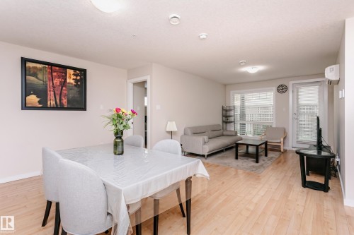 Open-concept living area featuring wood-finish flooring, recessed lighting, and neutral wall tones - #104 9519 160 Av Nw, Edmonton, AB - Indoor