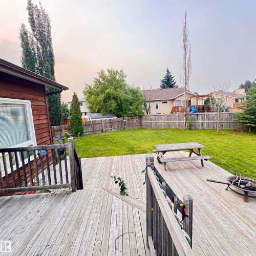 Expansive wood deck with railing overlooking a green lawn - 4821 11A Avenue Nw, Edmonton, AB - Outdoor With Exterior